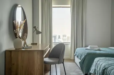 a bedroom with a bed and a desk and a mirror at GuestReady - Modern and luxe near JBR Beach in Dubai