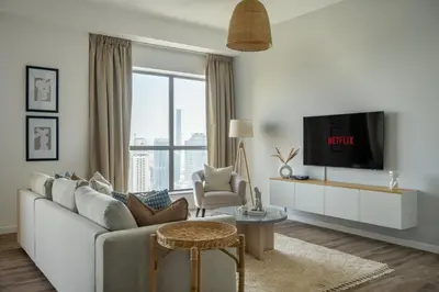 a living room with a couch and a tv at GuestReady - Modern and luxe near JBR Beach in Dubai