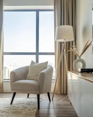a living room with a chair and a lamp at GuestReady - Modern and luxe near JBR Beach in Dubai