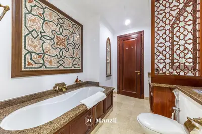 a bathroom with a tub and a toilet and a sink at Manzil - Cozy 2BR Penthouse with Private Terrace and Full Burj View in Downtown in Dubai
