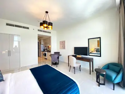 a bedroom with a blue bed and a desk at Lux BnB Studio Ghalia JVC in Dubai