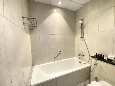 a white bathroom with a tub and a shower at Lux BnB Studio Ghalia JVC in Dubai