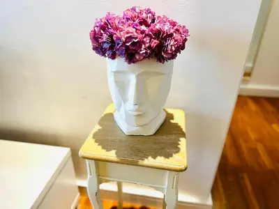 a vase filled with purple flowers sitting on a stool at Luxury Casa - Indigo Sea View Apartment JBR Beach 2BR in Dubai
