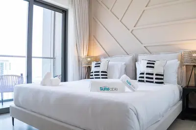 a large white bed in a room with a large window at Intimate Apartment with Scenic View of Dubai Creek in Dubai