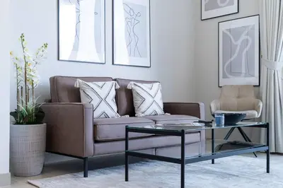 a living room with a couch and a glass table at Intimate Apartment with Scenic View of Dubai Creek in Dubai
