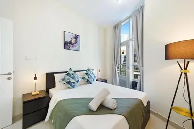 a white bedroom with a bed and a window at Impressive View 2BR in Dubai Marina Walk2Beach in Dubai