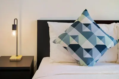 a bed with a pillow on it with a night stand at Impressive View 2BR in Dubai Marina Walk2Beach in Dubai