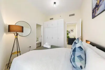 a bedroom with a white bed and a mirror at Impressive View 2BR in Dubai Marina Walk2Beach in Dubai