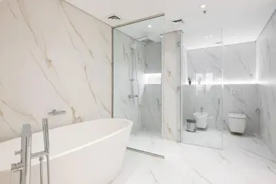 a white bathroom with a tub and a toilet at Upgraded Gorgeous 1BR at 5 Star Resort in Dubai