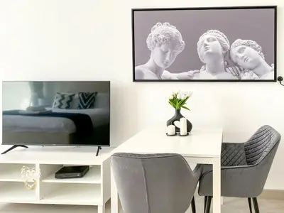 a room with a table and a tv and a bed at Stylish Studio Apartment in JVC with Contemporary in Dubai