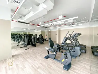 a gym with treadmills and elliptical machines at Stylish Studio Apartment in JVC with Contemporary in Dubai