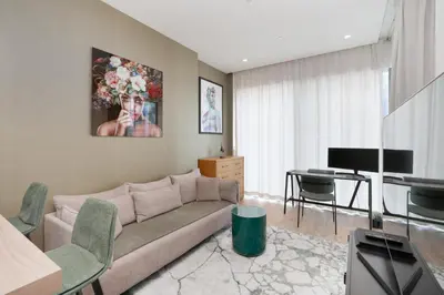 a living room with a couch and a desk at Vacay Lettings - Suite room in Marina gate, Jumeirah living in Dubai