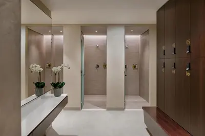 a bathroom with a walkin shower with vases of flowers at Vacay Lettings - Suite room in Marina gate, Jumeirah living in Dubai