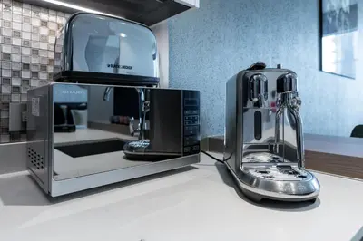 a coffee maker on a counter next to a microwave at Vacay Lettings - Suite room in Marina gate, Jumeirah living in Dubai