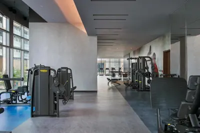a gym with treadmills and machines in a room at Vacay Lettings - Suite room in Marina gate, Jumeirah living in Dubai