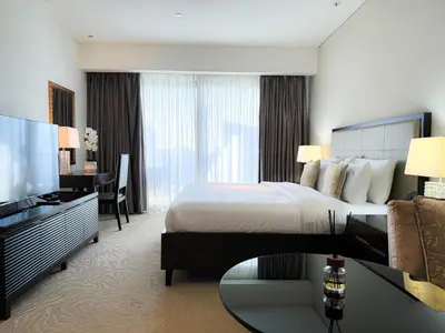 a hotel room with a bed and a desk and a television at Scenic view studio/Dubai Marina in Dubai