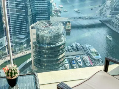 a view of a tall building with boats in the water at Scenic view studio/Dubai Marina in Dubai
