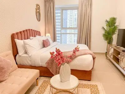 a living room with a bed and a couch at Cosmos Living Cozy Studio Near Dubai Marina in Dubai