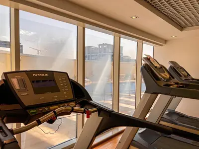 a gym with a treadmill and a large window at Cosmos Living Cozy Studio Near Dubai Marina in Dubai
