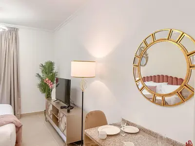 a living room with a mirror and a table at Cosmos Living Cozy Studio Near Dubai Marina in Dubai