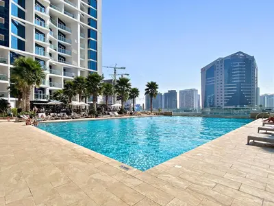 a swimming pool in a city with tall buildings at ALiving Modern Studio I Canal View I DAMAC Maison Prive A- 1102 in Dubai