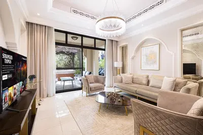a living room with a couch and a tv at Luxurious Unique 2 Bed with Private Jacuzzi & Garden - Connected to Souk Al Bahar - Dubai Mall in Dubai