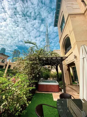 a patio with a table and chairs and a fountain at Luxurious Unique 2 Bed with Private Jacuzzi & Garden - Connected to Souk Al Bahar - Dubai Mall in Dubai