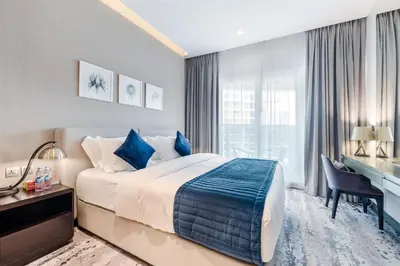 a bedroom with a bed and a desk and a computer at ALiving Cozy & Modern Studio I DAMAC Maison Prive, Business Bay -302 in Dubai