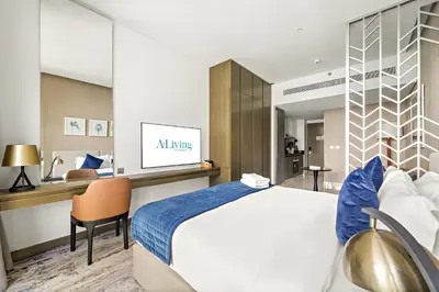 a hotel room with a large bed and a desk at ALiving Cozy & Modern Studio I DAMAC Maison Prive, Business Bay -302 in Dubai