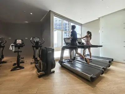 two people running on a treadmill in a gym at ALiving Cozy & Modern Studio I DAMAC Maison Prive, Business Bay -302 in Dubai