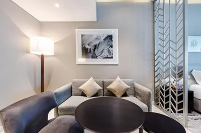 a living room with a couch and a table at ALiving Cozy & Modern Studio I DAMAC Maison Prive, Business Bay -302 in Dubai