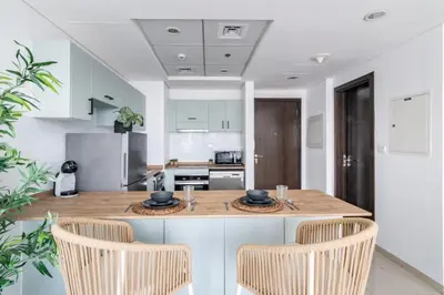 a kitchen with a wooden island with two chairs at GuestReady - Exquisite getaway with Marina views in Dubai