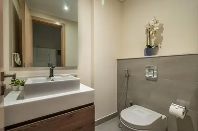 a bathroom with a sink and a toilet and a mirror at GuestReady - Luxurious Accents near Burj Khalifa in Dubai