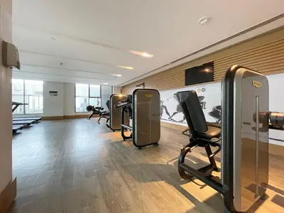 a fitness room with a row of exercise equipment at GuestReady - Luxurious Accents near Burj Khalifa in Dubai