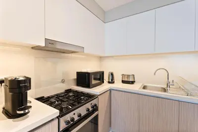 a kitchen with a stove and a sink at Elegant Luxury Apartment with Stunning Lake Views in Dubai Creek Harbour By ĀYA Boutique in Dubai