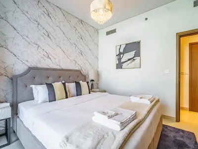 a bedroom with a large bed with towels on it at Bright and Splendid 1BR with Marina View in Dubai