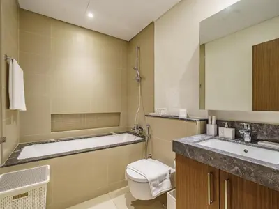 a bathroom with a tub and a toilet and a sink at Bright and Splendid 1BR with Marina View in Dubai
