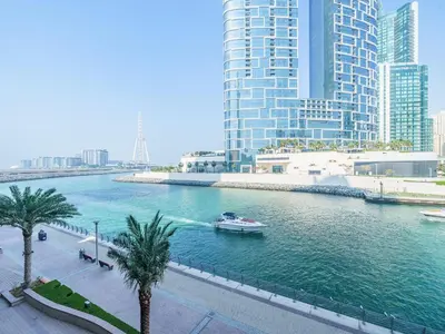a boat in a river in a city with tall buildings at Bright and Splendid 1BR with Marina View in Dubai