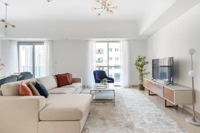 a white living room with a couch and a tv at Frank Porter - The Jwls T2 in Dubai