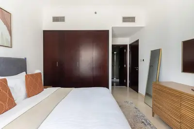 a bedroom with a large bed with a wooden headboard at Frank Porter - The Jwls T2 in Dubai