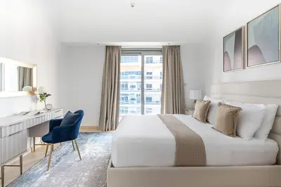 a bedroom with a bed and a desk and a window at Frank Porter - The Jwls T2 in Dubai