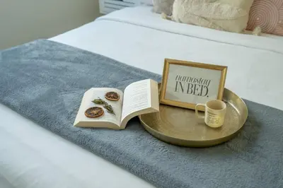 a tray with a book and a cup of coffee on a bed at GuestReady - Chic accents in Dubai Hills in Dubai