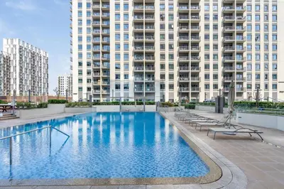 a large swimming pool in front of tall buildings at GuestReady - Chic accents in Dubai Hills in Dubai
