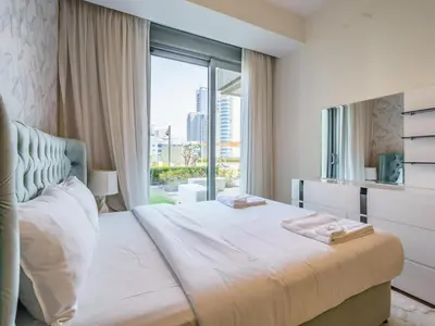 a bedroom with a large bed with a large window at Gorgeous 1 BR with Private Terrace - Marina View in Dubai