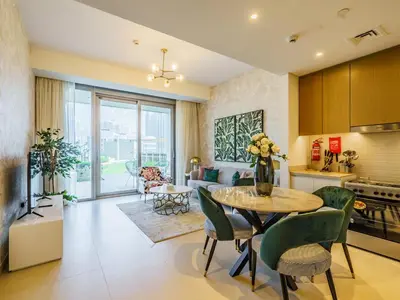a kitchen and living room with a table and chairs at Gorgeous 1 BR with Private Terrace - Marina View in Dubai