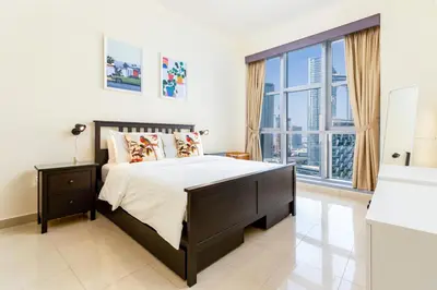 a bedroom with a large bed and a large window at Captivating Arabian Sea & Burj Khalifa Views in Dubai