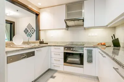 a kitchen with white cabinets and a sink at Captivating Arabian Sea & Burj Khalifa Views in Dubai