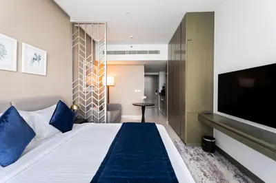 a hotel room with a large bed and a flat screen tv at ALiving Stylish Studio with Balcony I Partial Burj Khalifa View I DAMAC Maison Prive B-1315 in Dubai