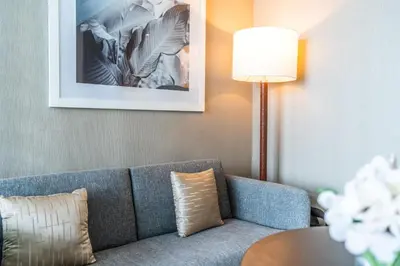 a living room with a couch and a table at ALiving Stylish Studio with Balcony I Partial Burj Khalifa View I DAMAC Maison Prive B-1315 in Dubai
