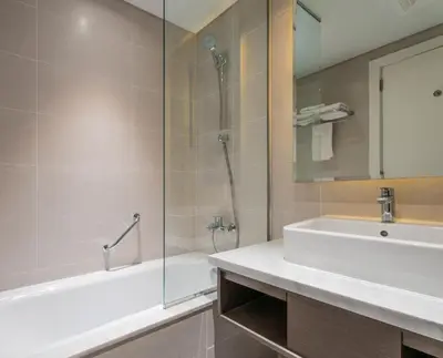 a bathroom with a tub and a sink and a shower at ALiving Stylish Studio with Balcony I Partial Burj Khalifa View I DAMAC Maison Prive B-1315 in Dubai